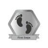 Silver bade that reads: first steps